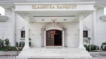 Un edificio con una entrada imponente, columnas y un letrero que dice 'Glamour Banquet'.