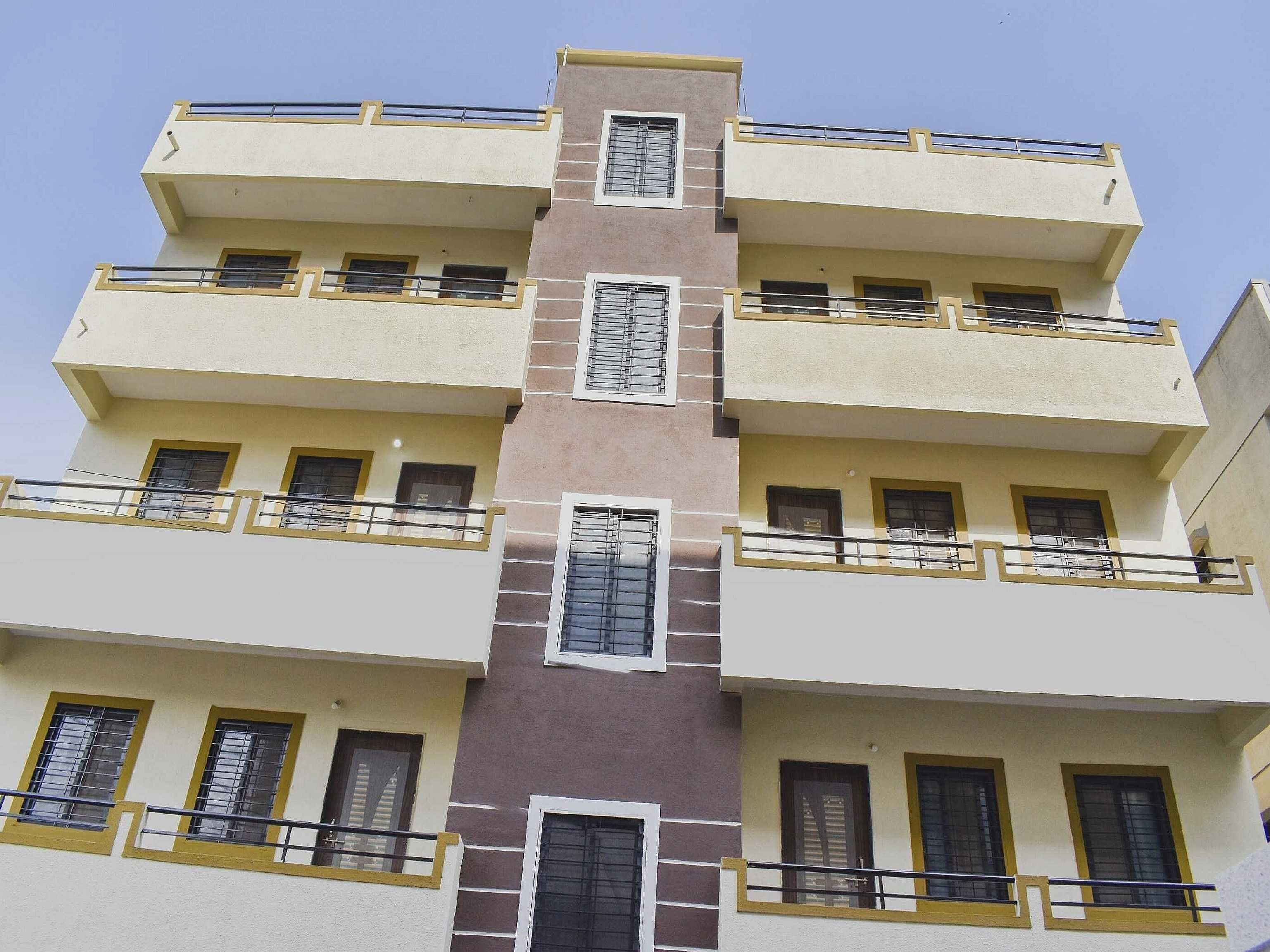 A multi-story residential building with balconies, windows, and a central vertical section.