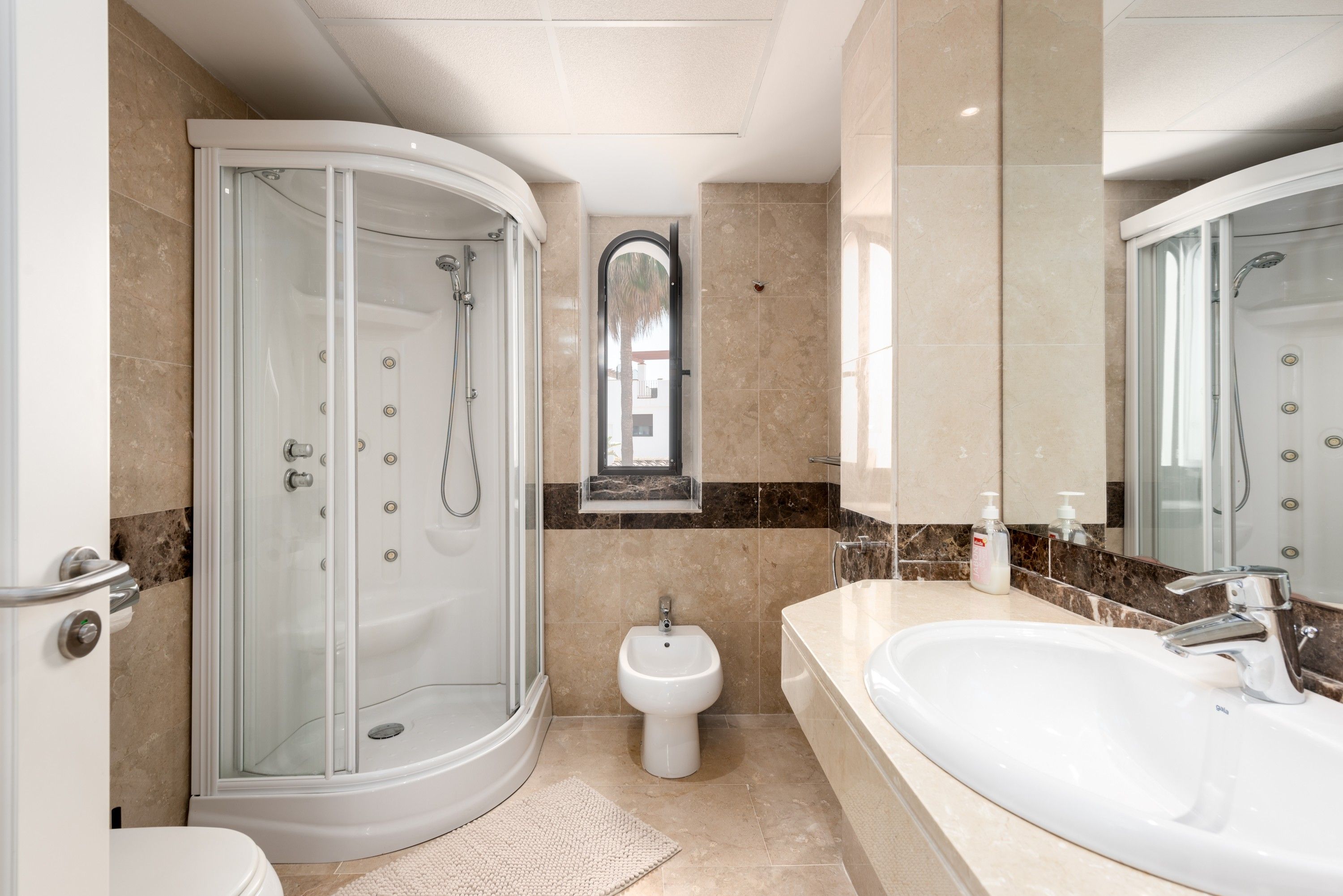 Un baño moderno con ducha envuelta en vidrio, un bidé y un lavamanos grande.