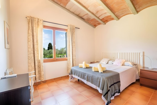 A bedroom with a bed, bedside tables, a desk, and a window with curtains. - Villa 'Unique" With Pool - Sea & Mountain View' (Port de Pollença)