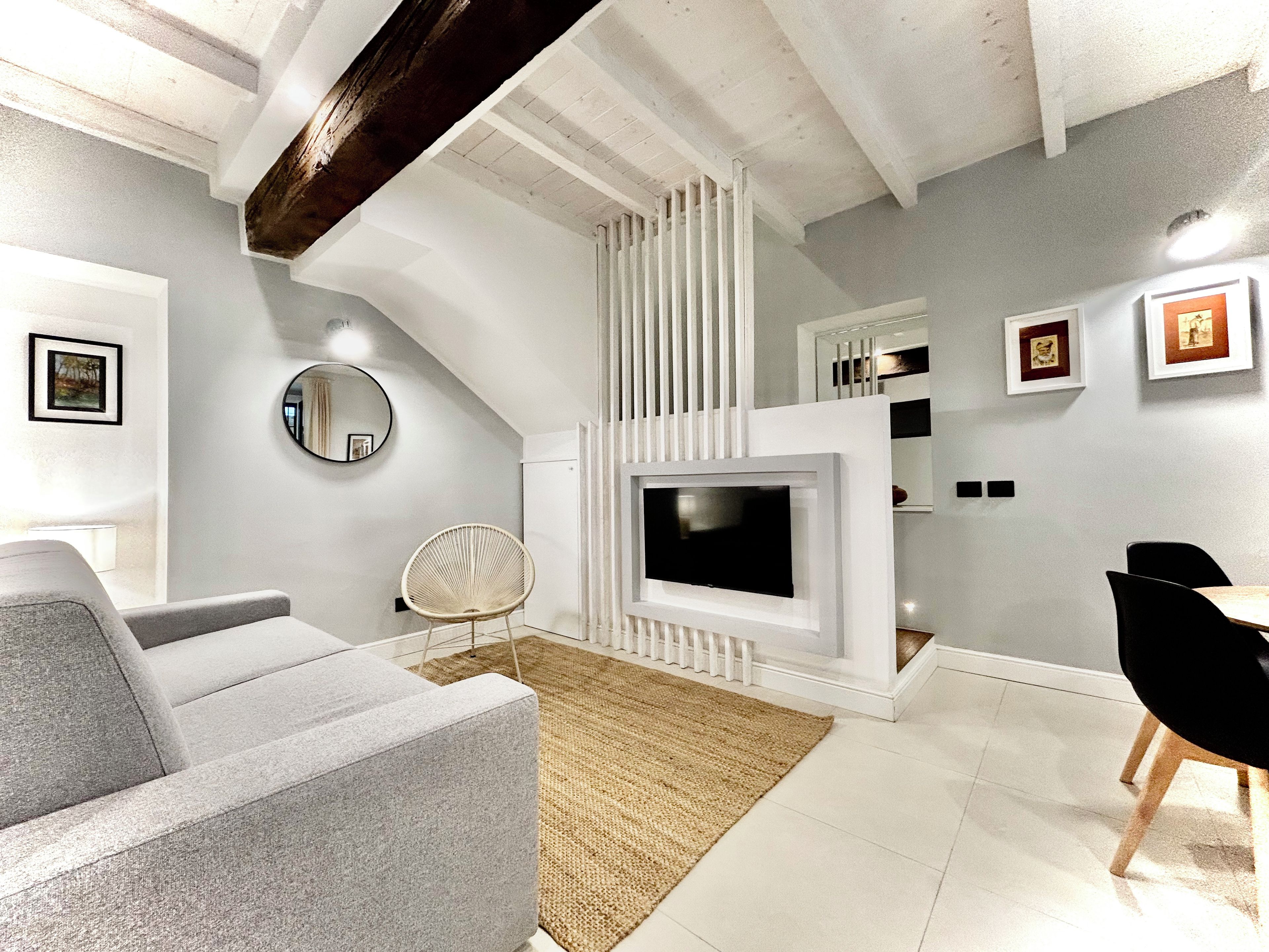 A modern living room with a fireplace, a television, and a dining area.