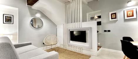 Una sala moderna con chimenea, televisión y comedor.