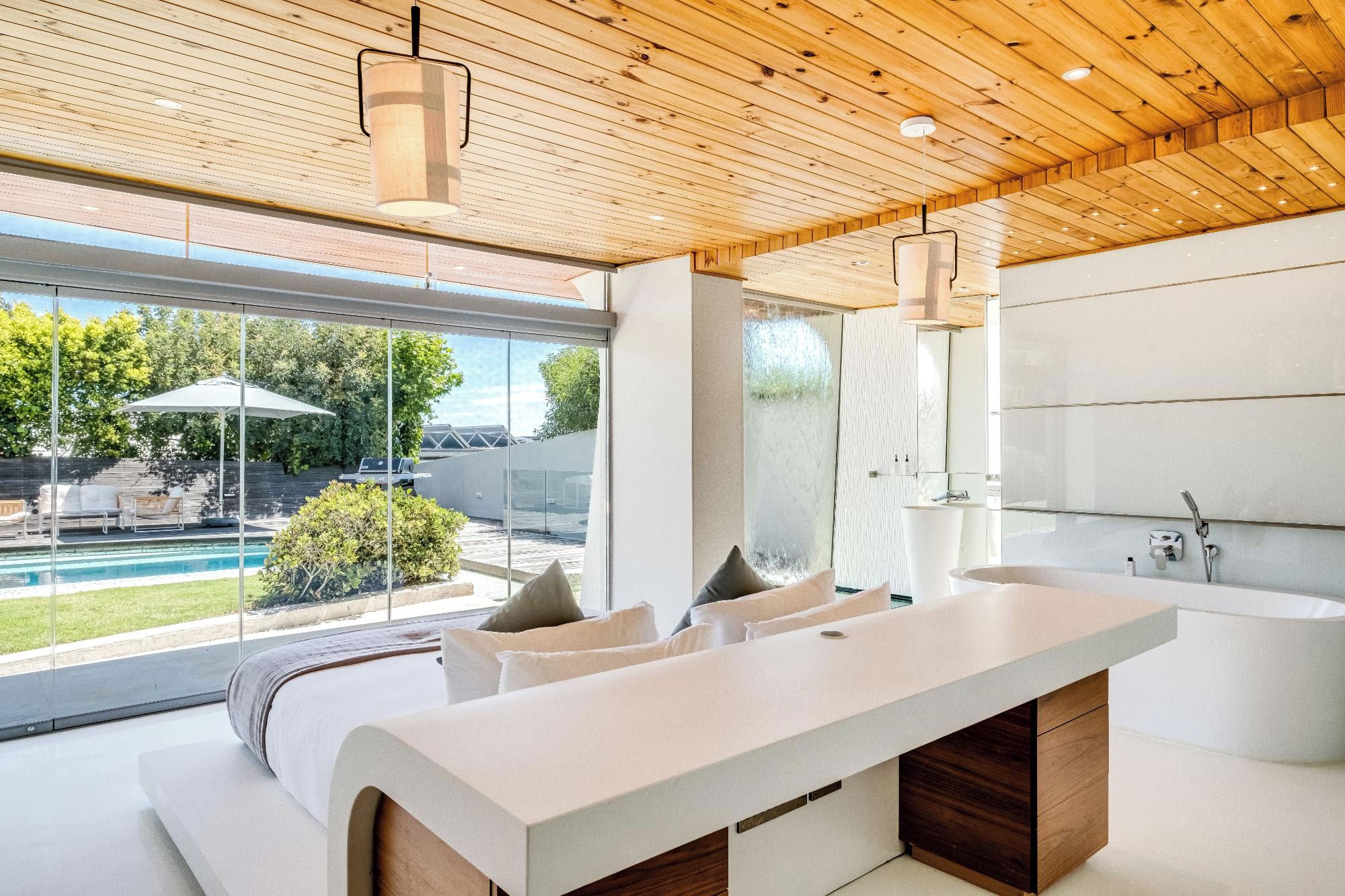 A modern bathroom with a large sink, a bathtub, and a glass shower enclosure.