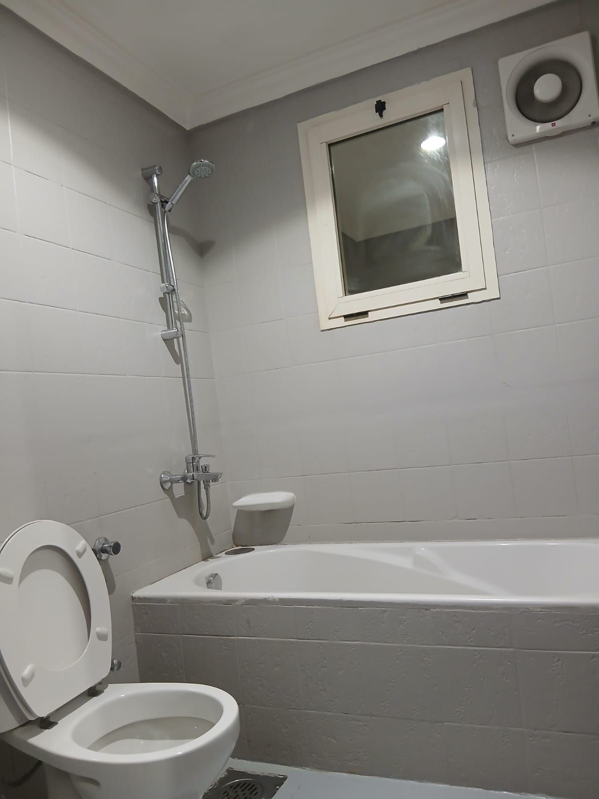 A bathroom with a toilet, a shower, and a bathtub.