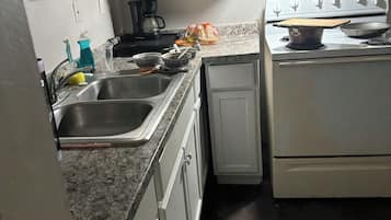 Una cocina con un fregadero, estufa, armarios y encimera.