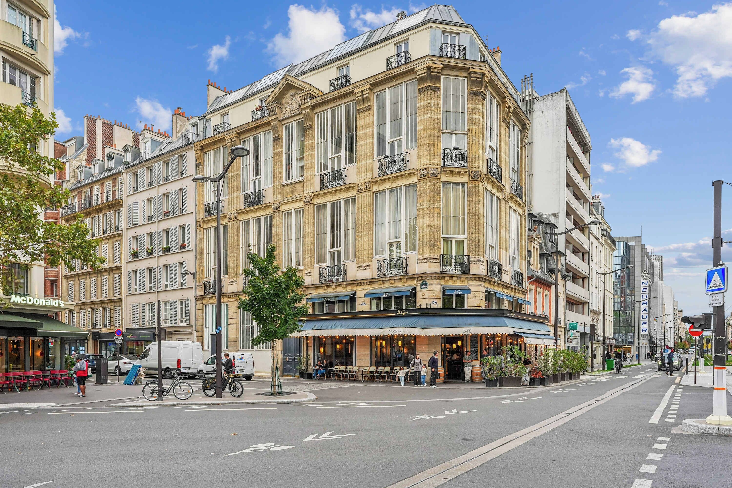 A street view with a corner building featuring a cafe and a McDonald's.