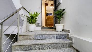 Una escalera con barandillas metálicas y macetas en la parte superior.