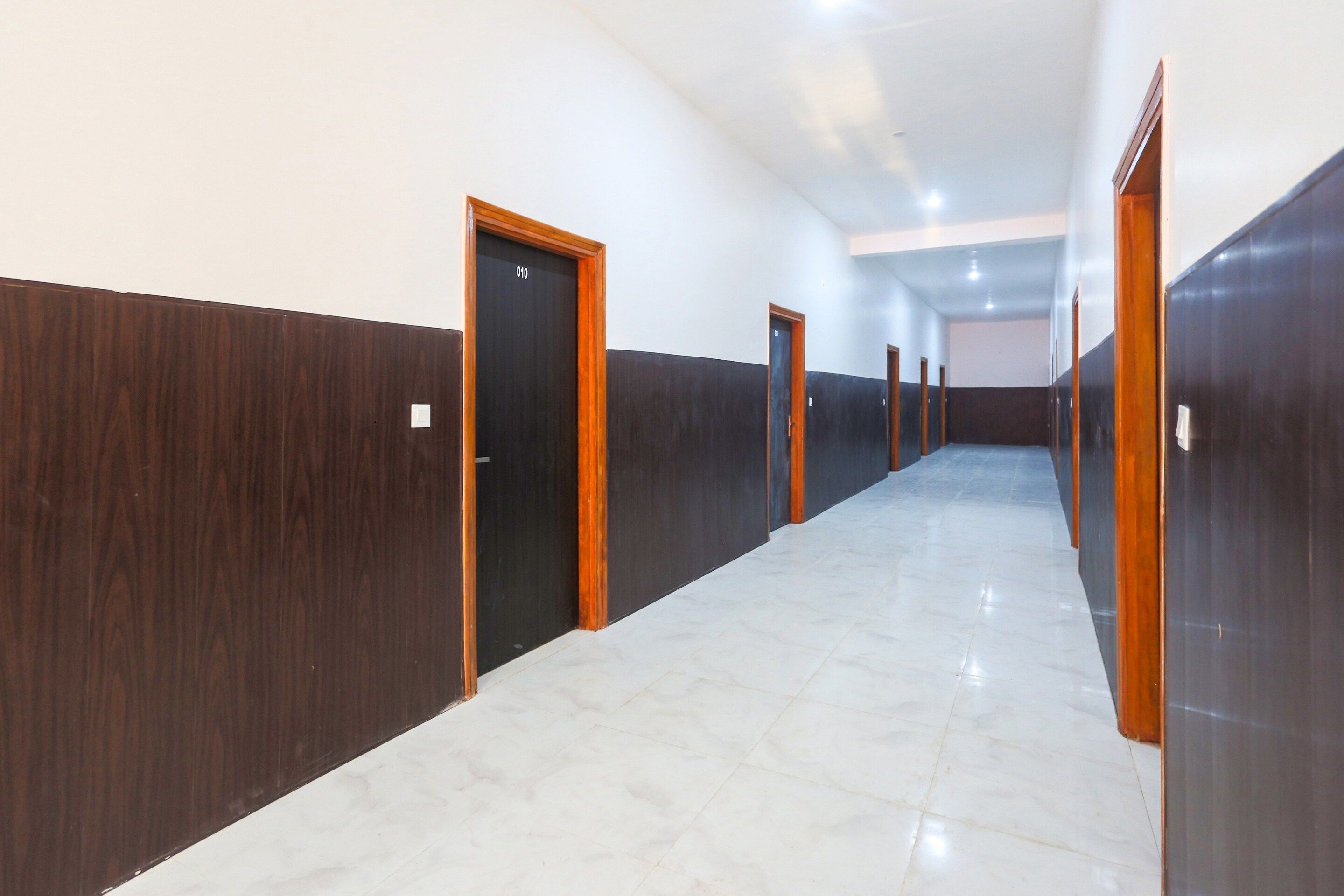 A long, narrow hallway with doors on both sides, leading to individual rooms.