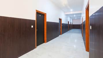 A long, narrow hallway with doors on both sides, leading to individual rooms.