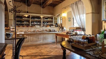 A restaurant interior with a bar area, wooden flooring, and a variety of food and drink items displayed.