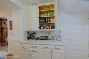 A kitchen with white cabinetry, a coffee maker, and a toaster on the counter.