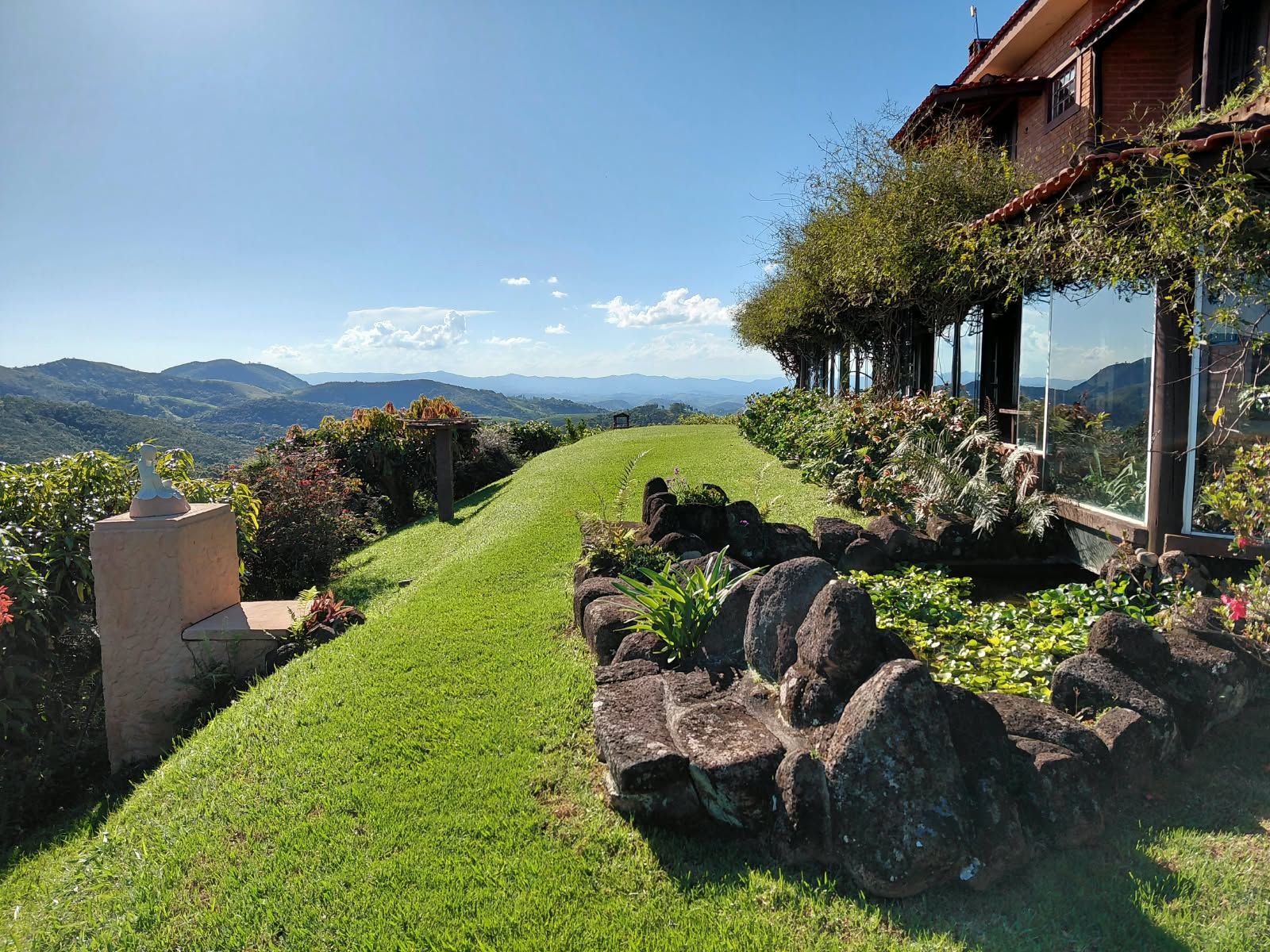 Un sendero bien cuidado que lleva a una casa con vista a montañas distantes.
