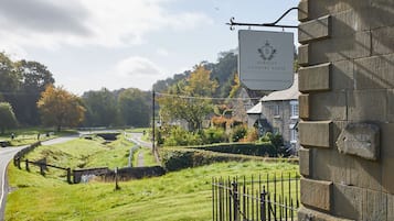 Un paisaje campestre con un cartel de Burnley Country House que indica que ofrece servicios de alojamiento y desayuno.