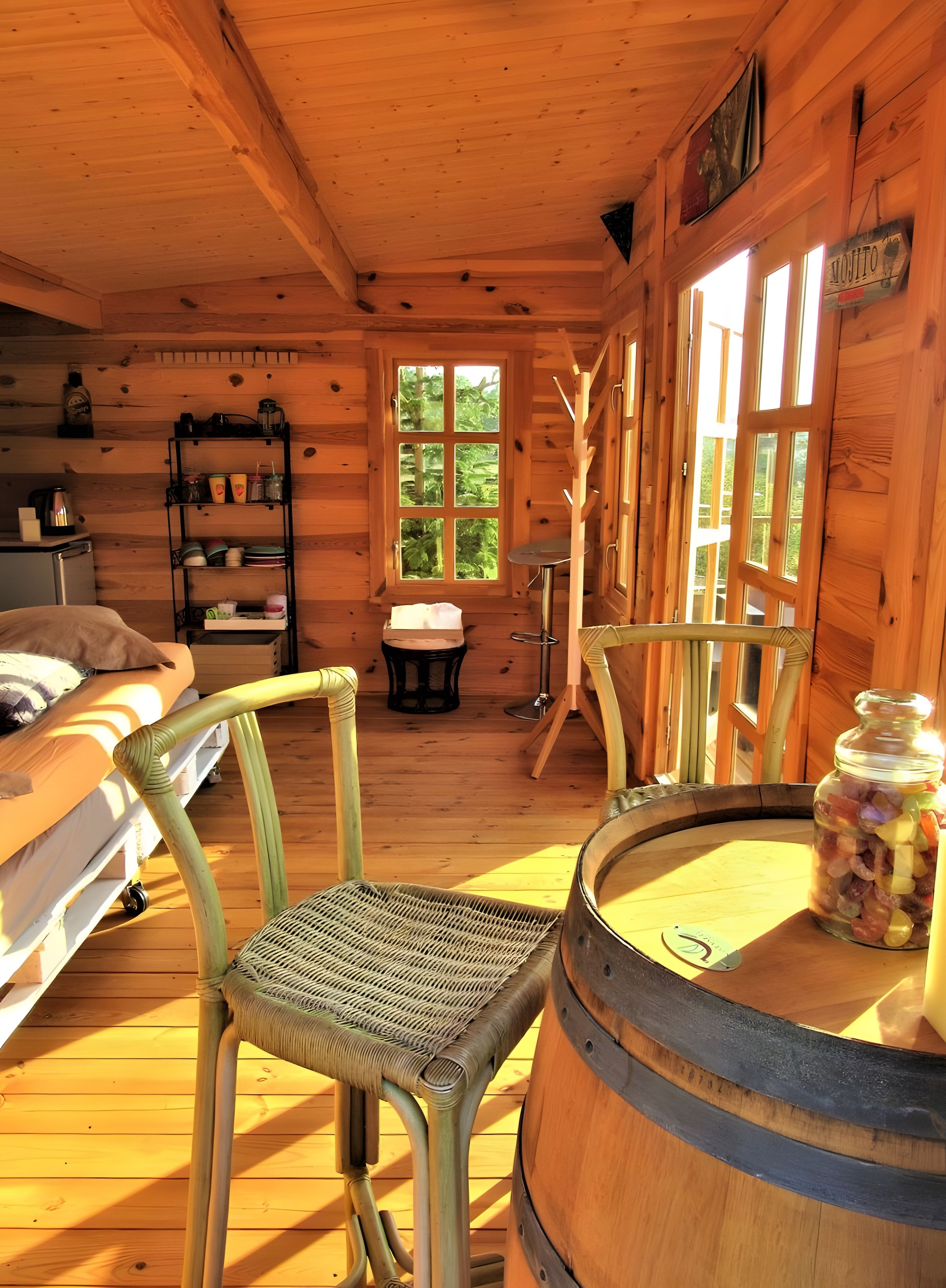 A cozy cabin interior with a wooden interior, a bunk bed, a dining table, and a large window.