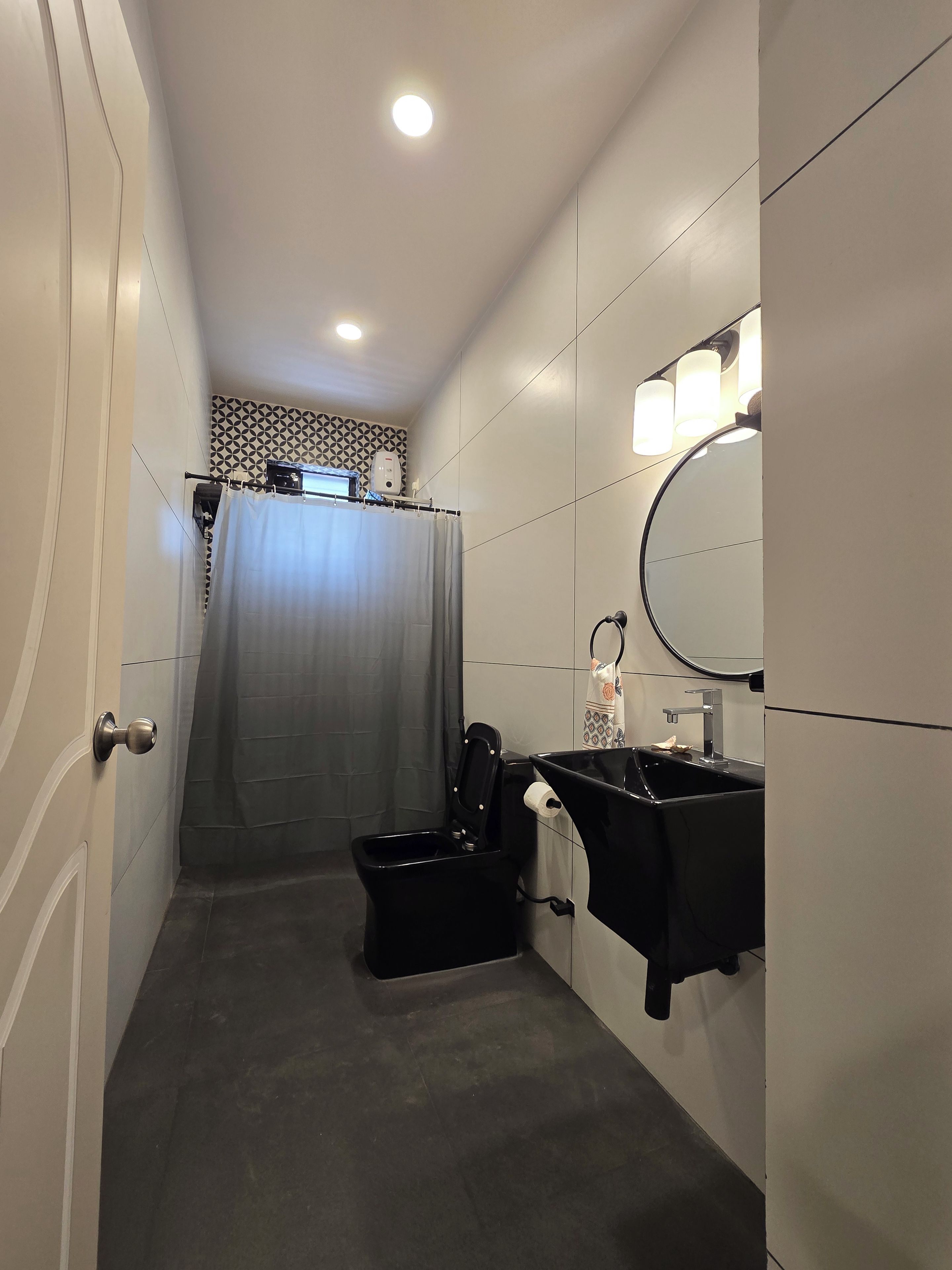 Een badkamer met douche, toilet en wastafel.