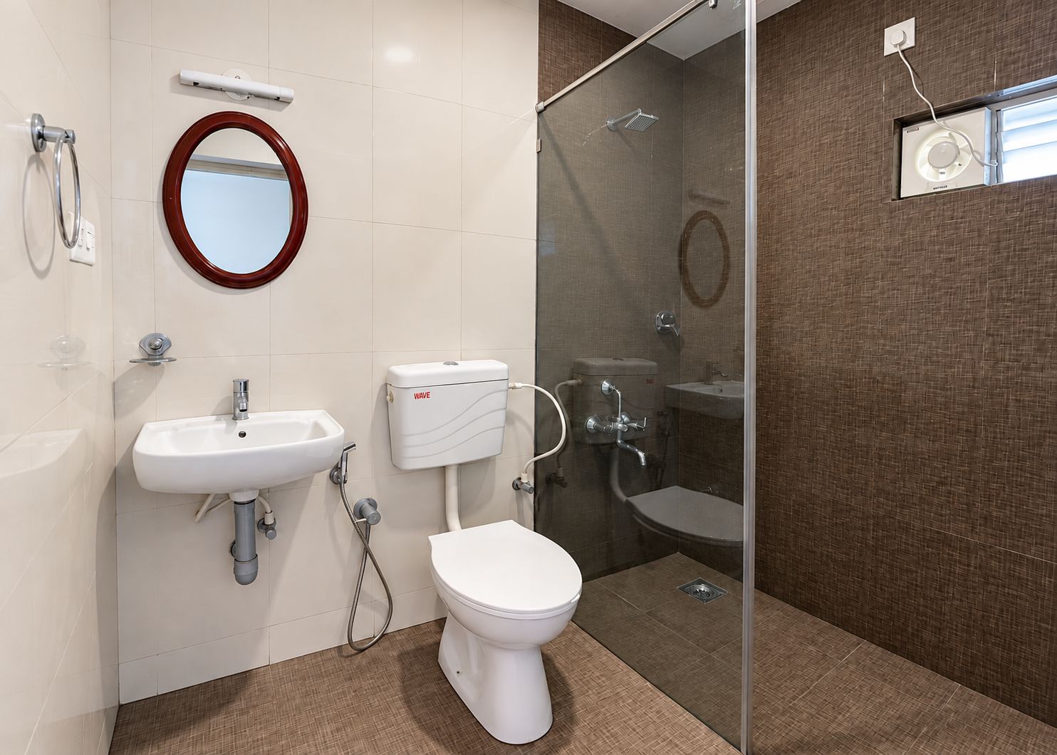 Et stilfuldt badeværelse med toilet, vask og bruseområde.