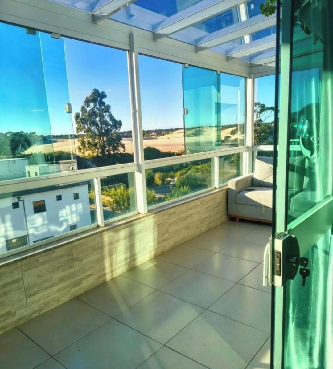 A modern room with large windows, a view of the countryside, and a glass door.