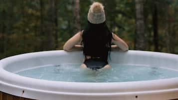 Una persona en un jacuzzi con el rótulo 'Nordic Hot Tubs' en el lateral.