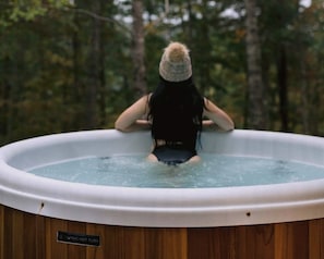 Una persona en un jacuzzi con el rótulo 'Nordic Hot Tubs' en el lateral.