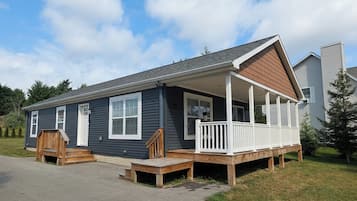 Een tweelaags huis met een veranda en een overdekte entree.