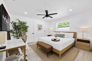 A modern bedroom with a bed, bedside tables, a desk, and a ceiling fan. - Sauna + Putting Green, 5 Min to Beach - The Oasis (Fort Lauderdale)