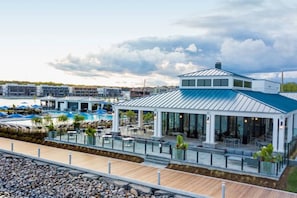 Propiedad frente al mar con zona de estar exterior cubierta, piscina y vistas al puerto deportivo.