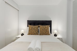 A hotel room with a bed, two nightstands, a headboard, and two lamps. - Luxury City Escape | Views and City Centre (Cape Town)