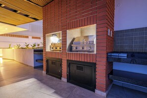 A modern kitchen with a brick wall, built-in gas stove, and a ventilation system. - York | Relaxed 1BR with Ocean Outlook (Umhlanga)