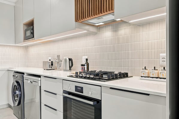 A modern kitchen with stainless steel appliances, a built-in oven, and a dishwasher. - York | Relaxed 1BR with Ocean Outlook (Umhlanga)