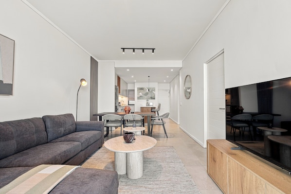 Ein modernes Wohnzimmer mit einem grauen Sofa, einem Couchtisch und einem TV-Schrank.