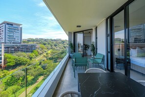 Een balkon met uitzicht op een stadsbeeld en groen.