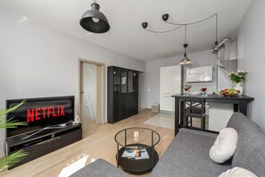 Ein modernes Wohnzimmer mit Flachbildfernseher, Couchtisch und Sofa.