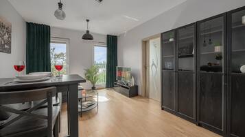 A modern kitchen with a dining table, chairs, and a TV displaying the Netflix logo.