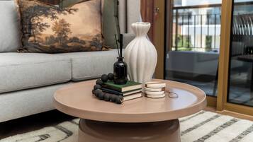 A round coffee table with a vase, books, and decorative items.