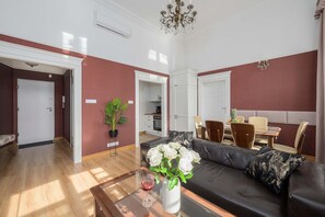 Ein modernes Wohnzimmer mit einer Couch, einem Couchtisch und einem Essbereich mit Stühlen.