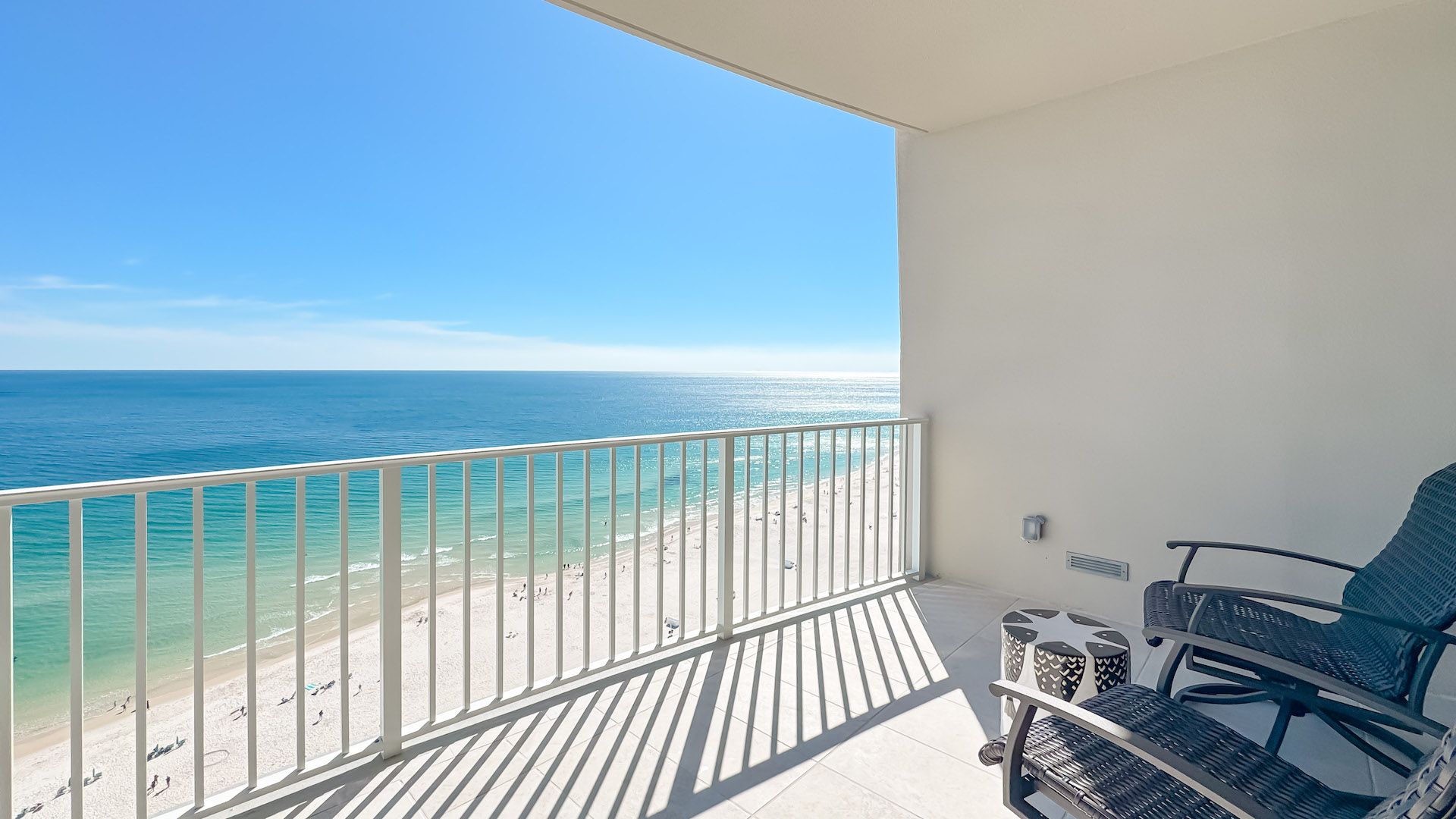 A balcony with a view of the beach and ocean.