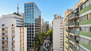 A multi-story building with a modern glass facade, surrounded by other residential buildings.