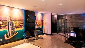 Quarto de hotel moderno com um grande mural da paisagem urbana, varanda envidraçada e mobiliário contemporâneo.