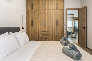 A bedroom with a bed, a wardrobe, and a bathroom visible through an open door.