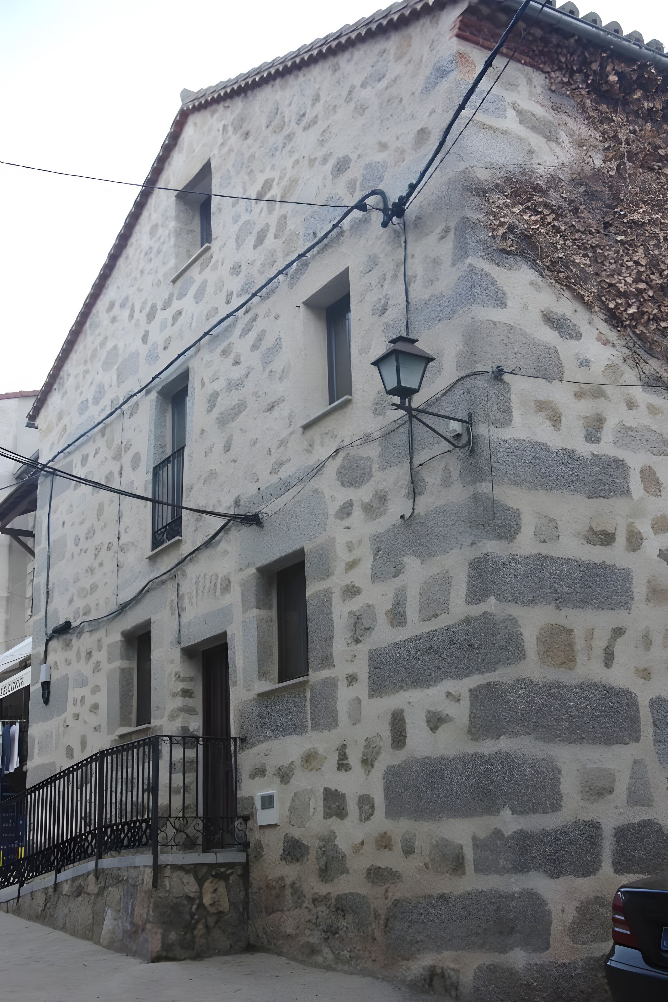 Un bâtiment en pierre doté d’un balcon et d’un lampadaire.