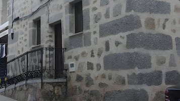 Un bâtiment en pierre doté d’un balcon et d’un lampadaire.