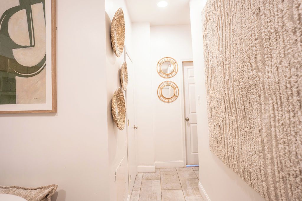 A hallway with a textured wall, a door, and decorative wall art.