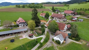 Un borgo rurale caratterizzato da case tradizionali, un centro comunitario e un impianto di pannelli solari.