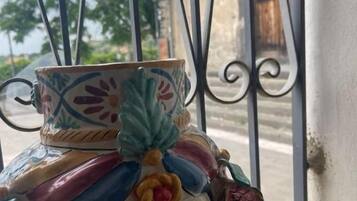 A ceramic pot with a floral design on a windowsill.