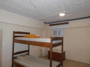 Habitació amb literes, finestra i llum al sostre.