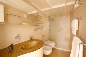 Un bagno con vasca, WC e doccia.