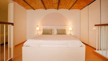 A bedroom with a large bed, two bedside lamps, and a wooden ceiling.
