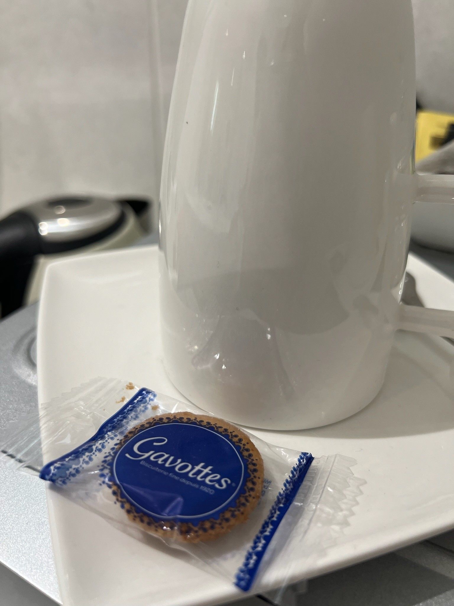Een witte kop op een witte schaal, met een blauw pakje met de naam 'Gavottes' ernaast.