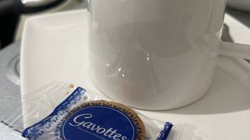 Een witte kop op een witte schaal, met een blauw pakje met de naam 'Gavottes' ernaast.
