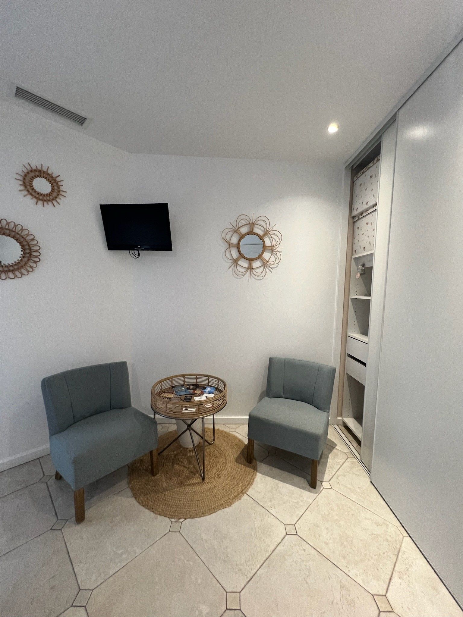 A small living room with two sofas, a coffee table, a TV, decorative wall art, and a built-in shelving unit.